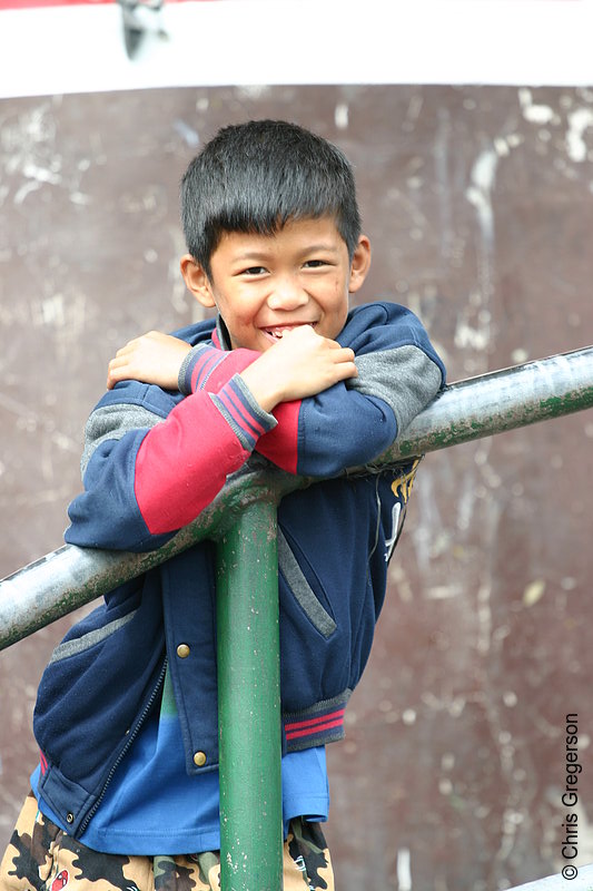 Photo of Smiling Boy Leans Over the Railing of a Sidewalk in Baguio City, Philippines(5760)