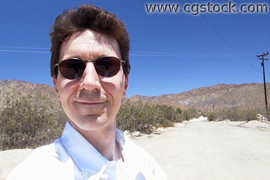 Young Man with Sunglasses on a Desert Road