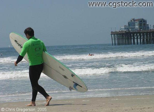 Man Heading out to Surf, Oceanside