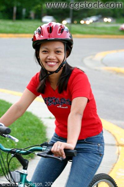 Young Woman Smiling on a Bicycle (at Rest)