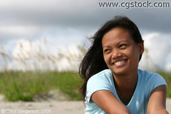 Young Asian Woman Sitting, Smiling on Beach