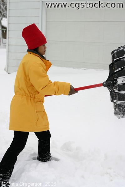 Woman Shovelling Snow in Driveway