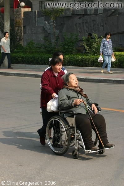 Older Chinese Woman in Wheelchair, Road in Beijing