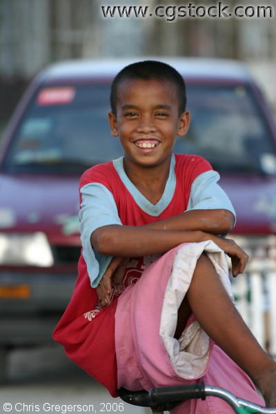 Image of a Street Boy on a Bicycle Smiling