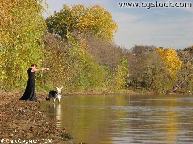Young Woman and Dog on the Lakeshore in Fall