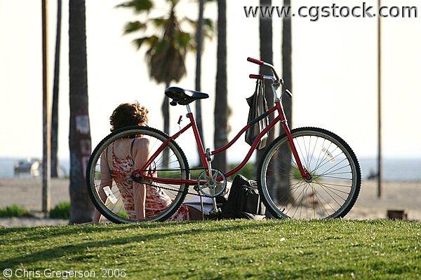 Woman Relaxing Next to Bike, Venice Beach, CA