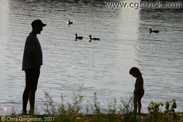 Father and Child in Silhouette on Lakeshore