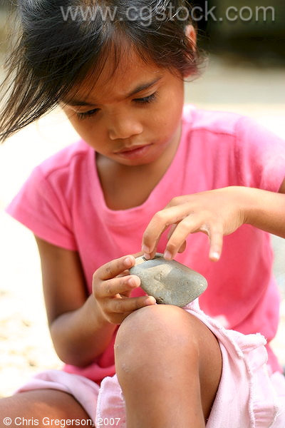 Pre-School Girl Playing with a Rock, the Philippines
