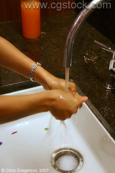 Woman Washing Hands at a Sink