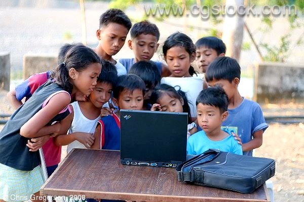 Children Gathered Around a Laptop Computer in the rural Philippines
